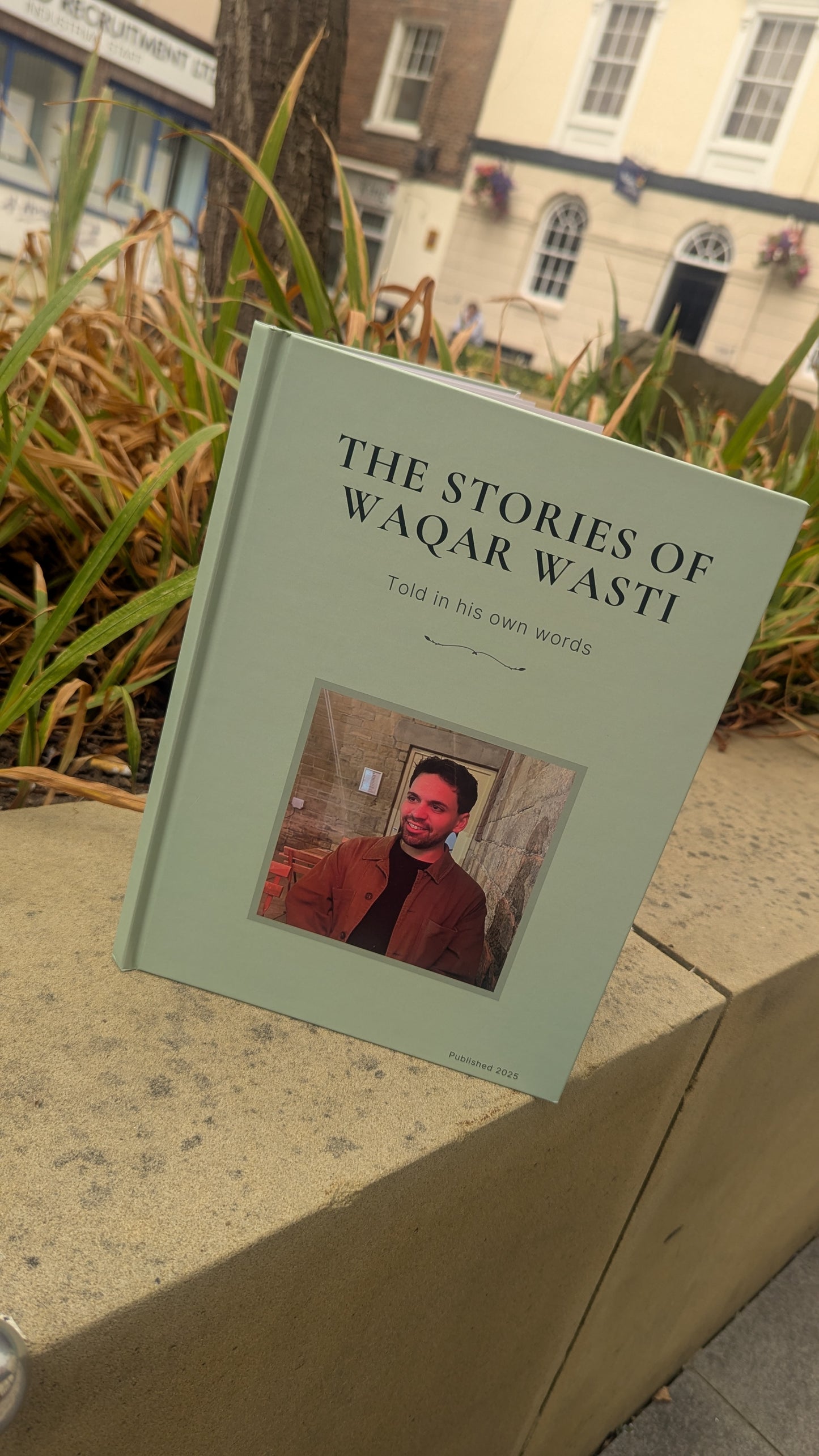 Book titled 'The Stories of Waqar Wasti' on a ledge with a blurred background