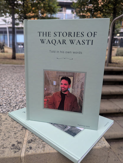 Book titled 'The Stories of Waqar Wasti' with a photo of a man on the cover, placed outdoors.