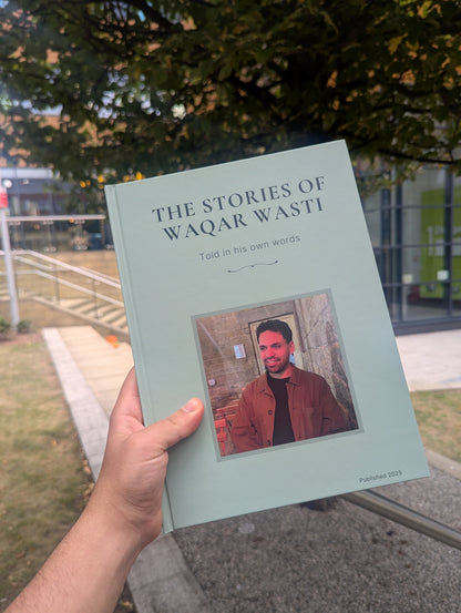 Book titled 'The Stories of Waqar Wasti' held by a person outdoors.